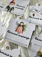 Ziemassvētku dāvanu kartītes ar uzrakstu “Dāvanas saņēmējs”, drukātas uz fotopapīra. Maigi, rotaļīgi dizaini ar ziemas motīviem – eglītēm, karstās šokolādes krūzītēm, piparkūkām ar dāvanām un citām svētku ilustrācijām.