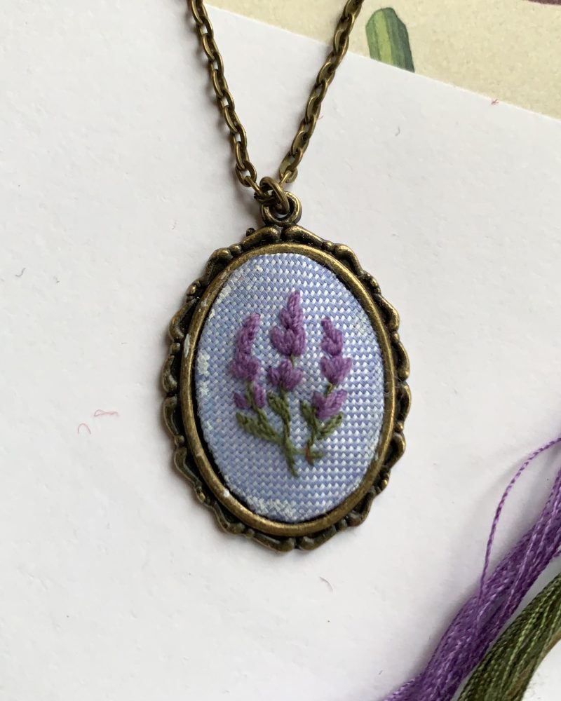 Ovāls kulons ar izšūtiem lavandas ziediem ķēdītē