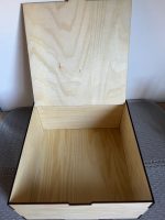 Koka kastīte ar žirafes un tauriņu gravējumu, skatīta no augšas.