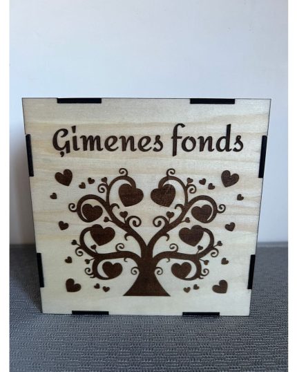 Koka krājkase ar uzrakstu "Ģimenes fonds" un gravētu koka siluetu ar sirds motīviem.