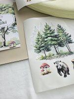 Meža dzīvnieku līmpapīra sienas uzlīmes bērnu istabā – lapsa, lācis, stirna, putni un koki izvietoti bērnu gultiņas garumā uz gaišas sienas.