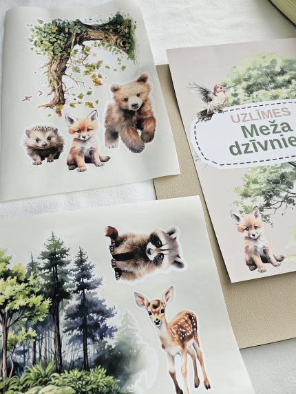 Meža dzīvnieku līmpapīra sienas uzlīmes bērnu istabā – lapsa, lācis, stirna, putni un koki izvietoti bērnu gultiņas garumā uz gaišas sienas.