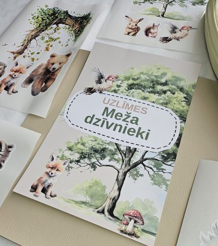 Meža dzīvnieku līmpapīra sienas uzlīmes bērnu istabā – lapsa, lācis, stirna, putni un koki izvietoti bērnu gultiņas garumā uz gaišas sienas.