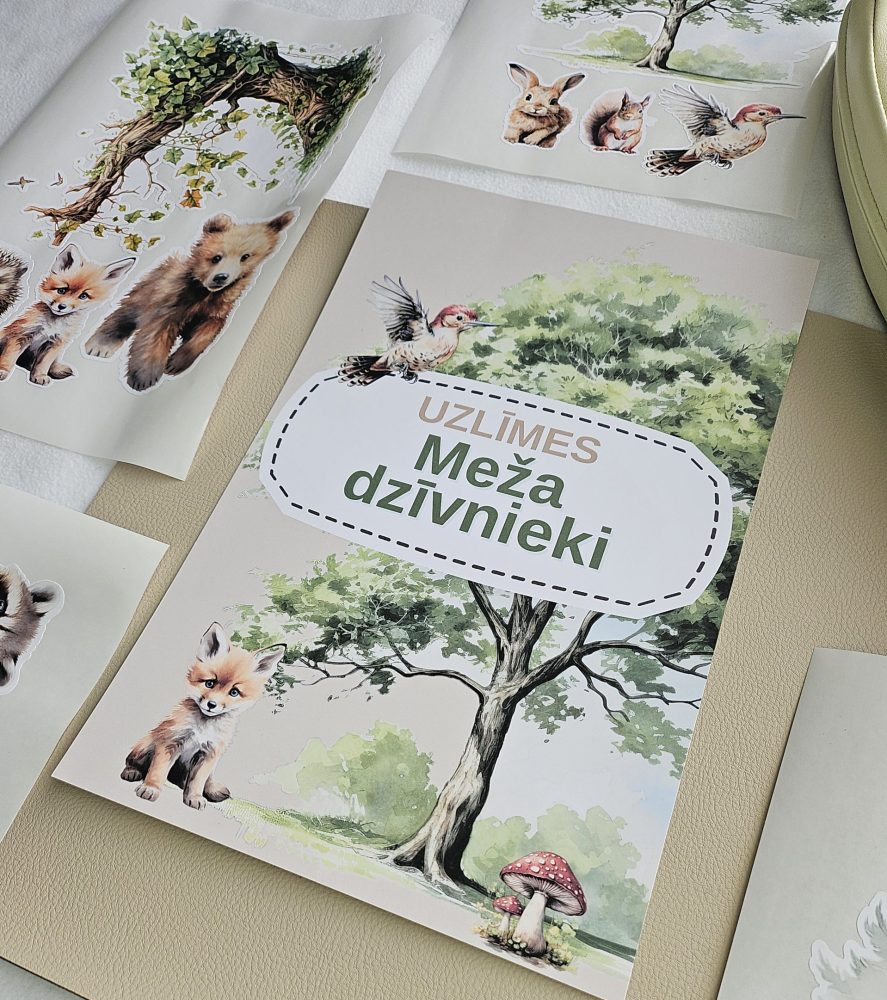 Meža dzīvnieku līmpapīra sienas uzlīmes bērnu istabā – lapsa, lācis, stirna, putni un koki izvietoti bērnu gultiņas garumā uz gaišas sienas.