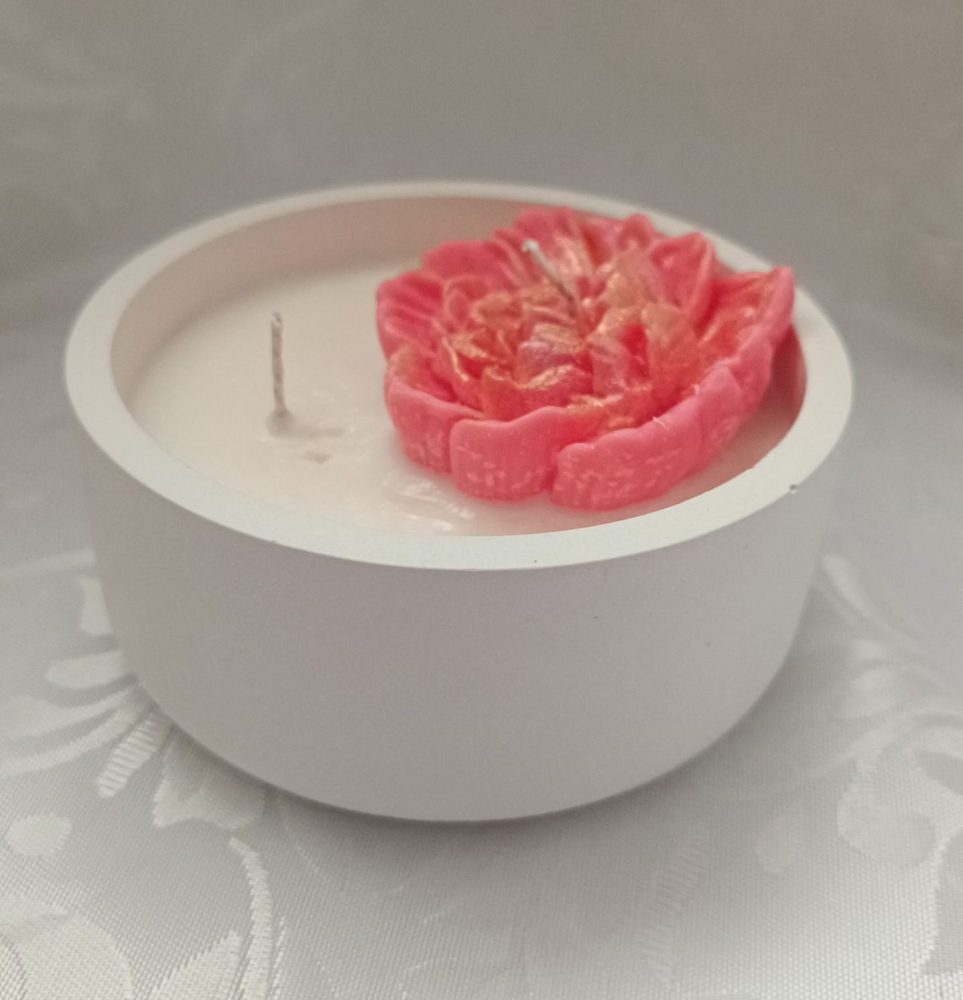 Svece baltā ģipša trauciņā rožu