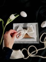 Rokā turēta balta lina matu bante ar zaķīša izšuvumu un cirkonija pērlītēm, eleganta matu rota meitenei svētkiem vai fotosesijai.