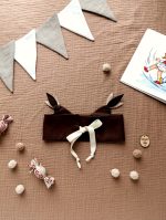 Regulējama pūces maska ar kokvilnas aukliņu, ērti pielāgojama bērna galvai.