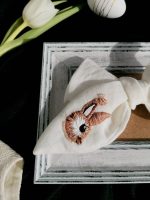 Tuvplāns – zaķīša rokdarba izšuvums uz baltas lina matu bantes, dekorēts ar cirkonija pērlītēm un smalkām detaļām.