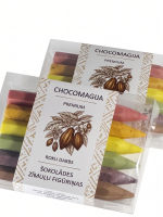 "Chocomagija Premium" roku darba šokolādes zīmuļu figūriņu komplekti caurspīdīgā iepakojumā. Kastītē redzami seši dažādu krāsu šokolādes zīmuļi — sārts, dzeltens, gaiši dzeltens, zaļš, violets un brūns. Uz baltās iepakojuma joslas attēlota kakao zara un pupiņu ilustrācija, kā arī uzraksts "Šokolādes zīmuļu figūriņas. Baltā un piena šokolāde ar ogām, augļiem, zaļumiem".
